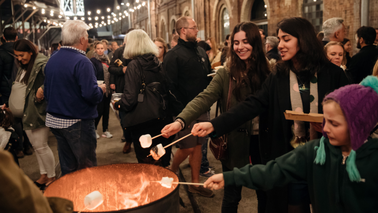 People toasting marshmallows at the Carriageworks Night Market