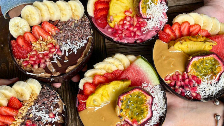 Five acai bowls with fresh fruit