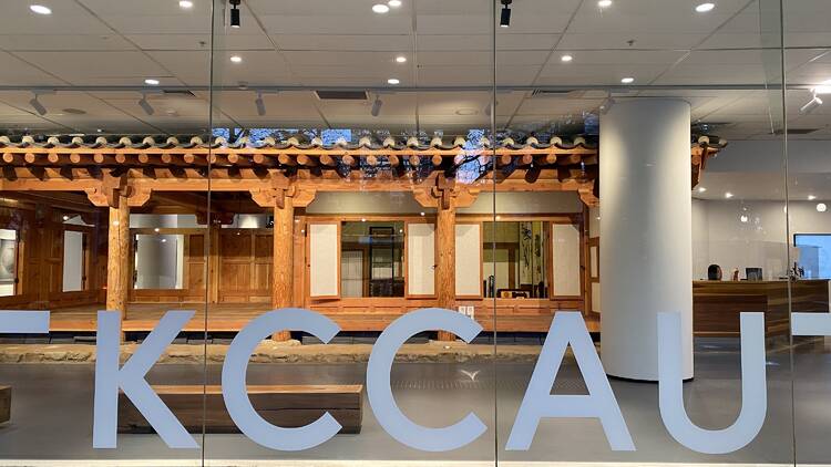 A front entrance with some letters on the glass that say: KCCAU