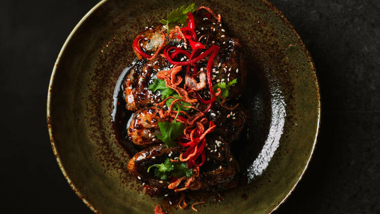 An Asian-looking meal in a dark bowl, shot from above.