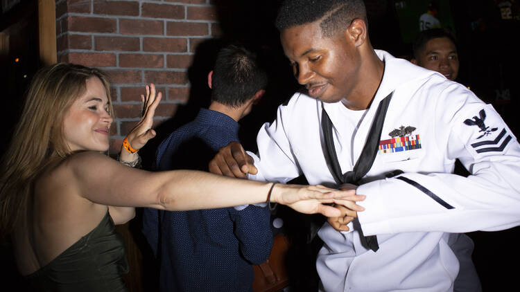 A sailor in uniform dances with a woman. 