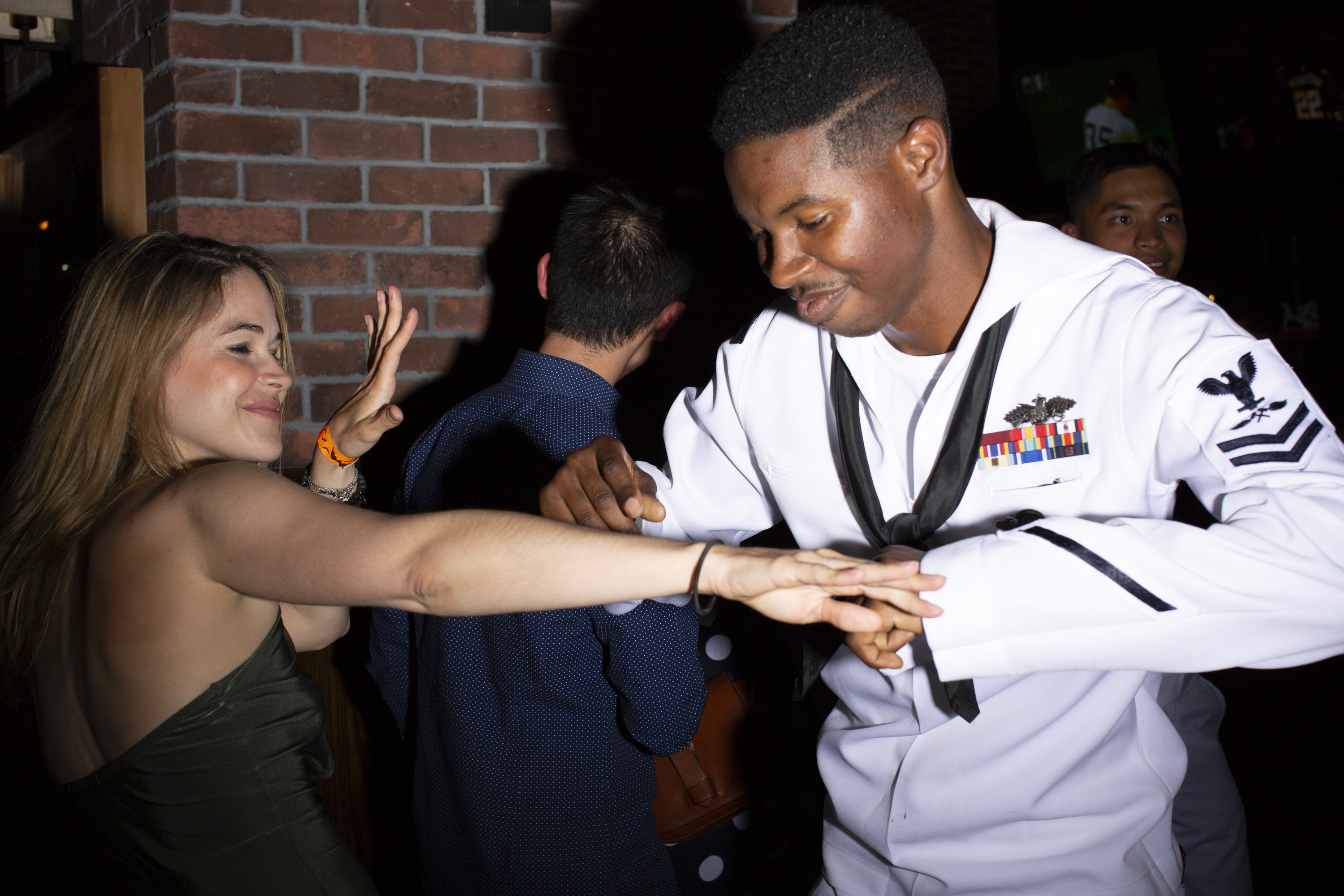 A sailor in uniform dances with a woman. 