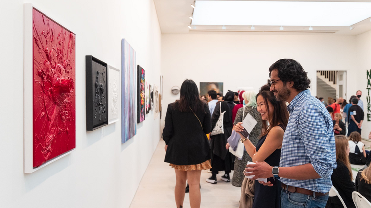 A group of people look at art. 