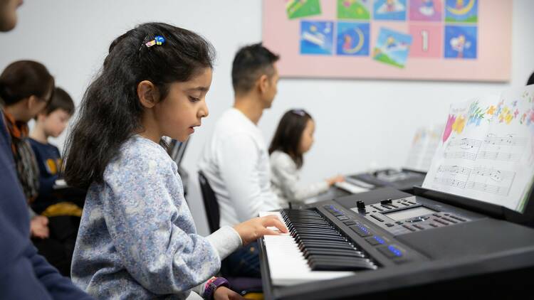 A child plays a keyboard at Yamaha Music School