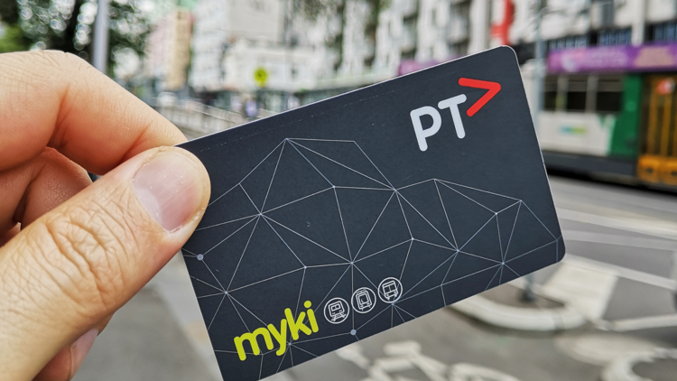 A person holds a Myki card up.