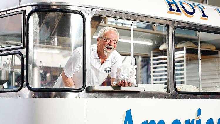 Man smiling in a doughnut food truck.