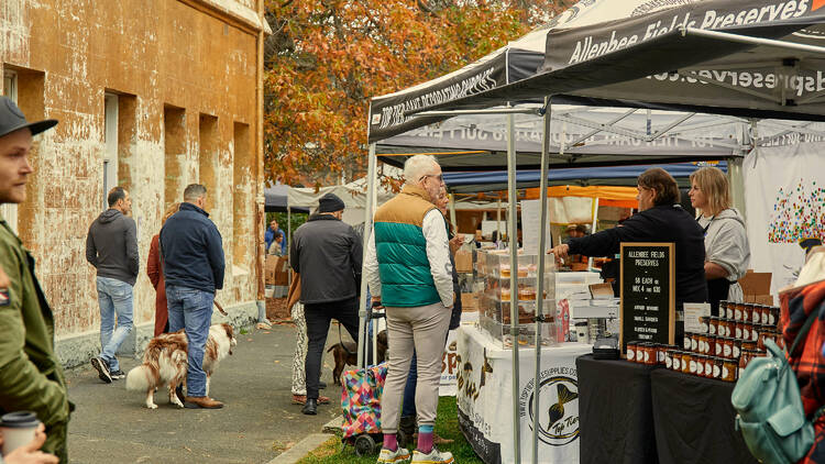 People walking around an outdoor farmers market.