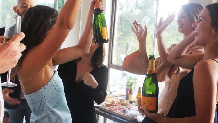 People celebrating with bottles of Veuve Champagne.