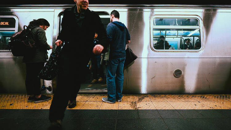 Man running through crowded subway platform