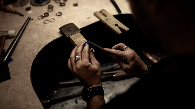 A jeweller working with tools to create a ring.