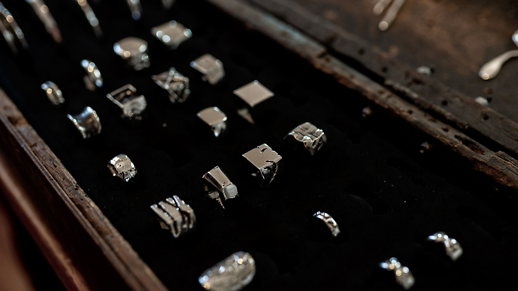 A black case holding rows of silver rings.