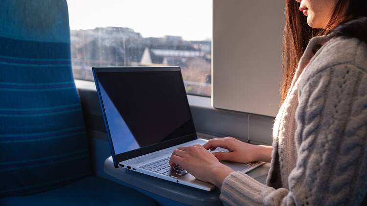 Woman using laptop on train