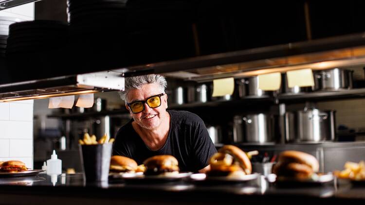 Chef Sean Connolly in the kitchen with burgers