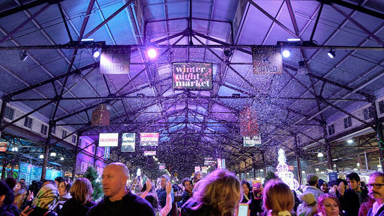 An undercover market shed with fake snow and purple lighting.