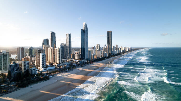 A Gold Coast beach with skyscrapers on the coastline.