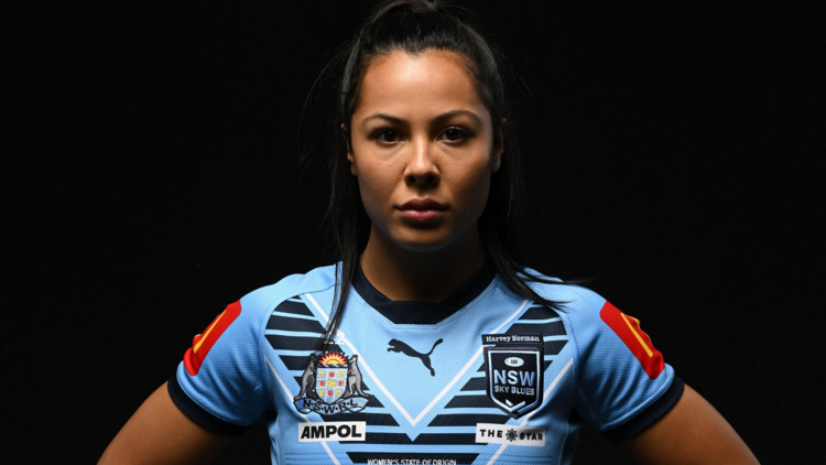 A women's rugby league player wearing a blue jersey.
