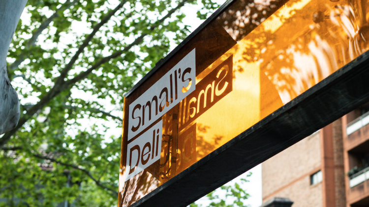 The orange Small's Deli sign outside the shop