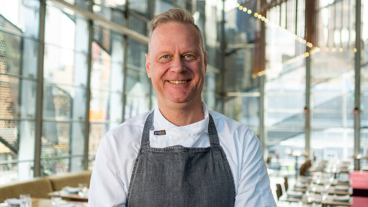 Michael Lambie smiling in an apron at Taxi Kitchen.