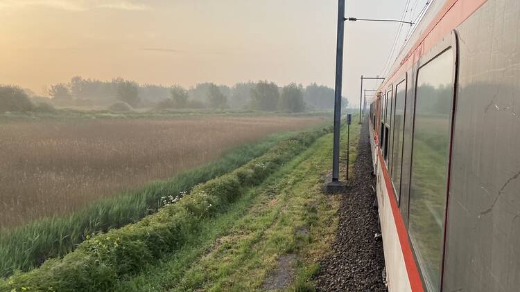 European Sleeper train passing through fields at golden hour