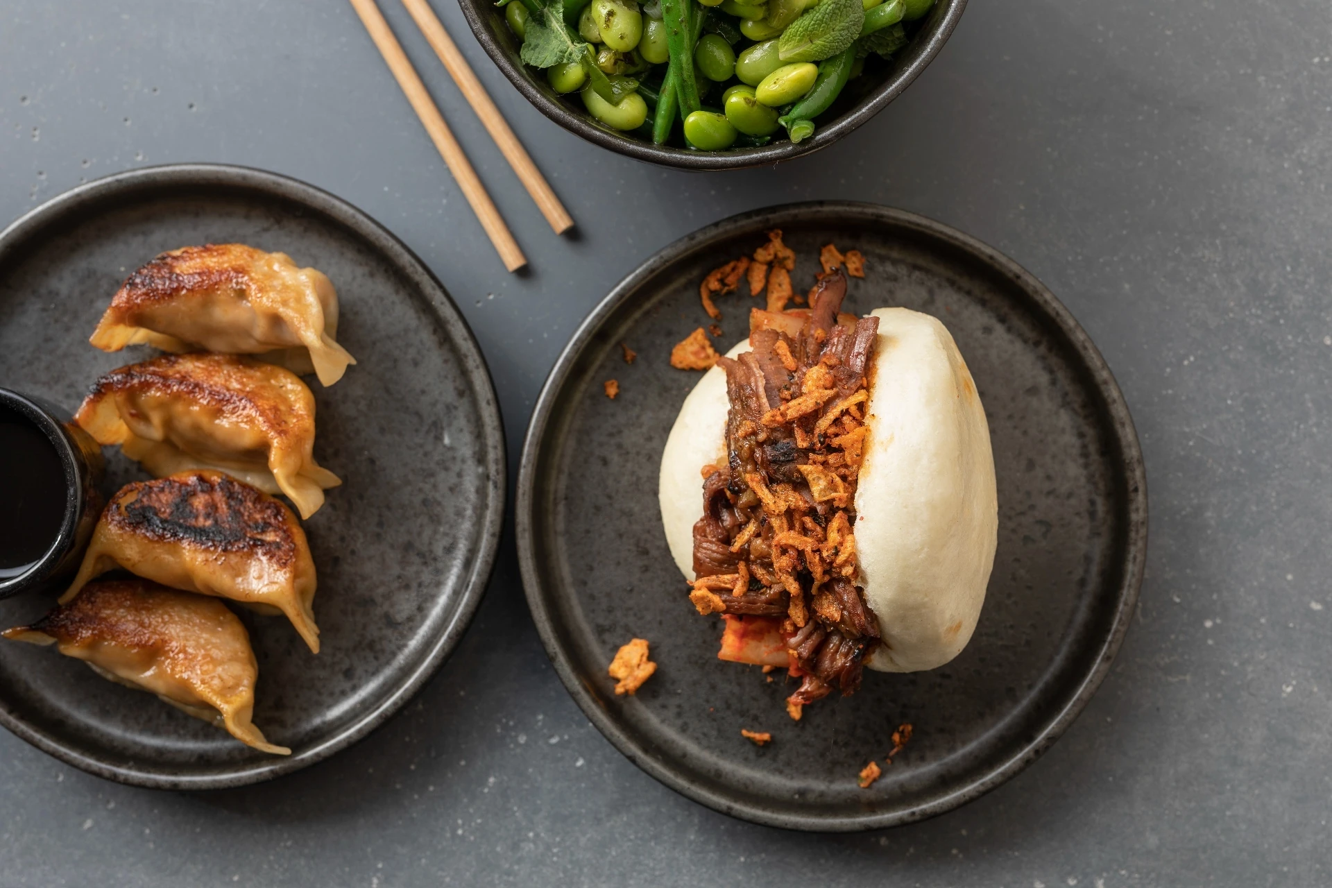 Birds eye view of a bao bun and gyozas