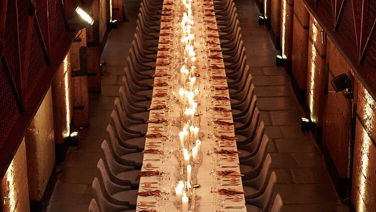 Long candelit dinner table at Old Melbourne Gaol.