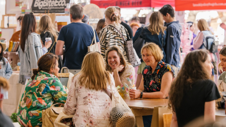 Women sitting at a table at the market laughing