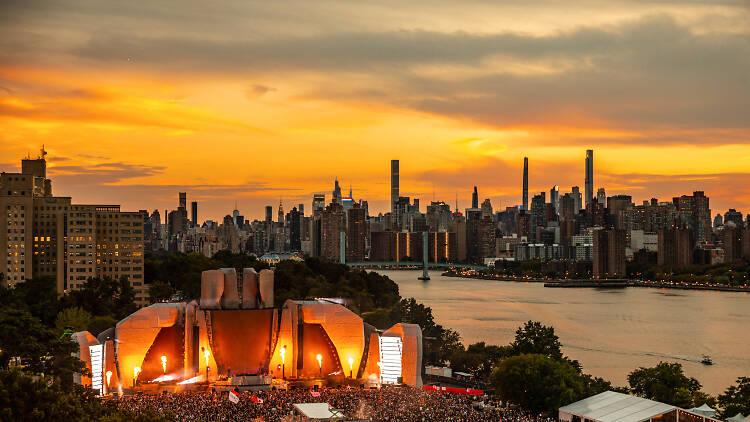 A stage with a packed crowd; the NYC skyline appears in the background.