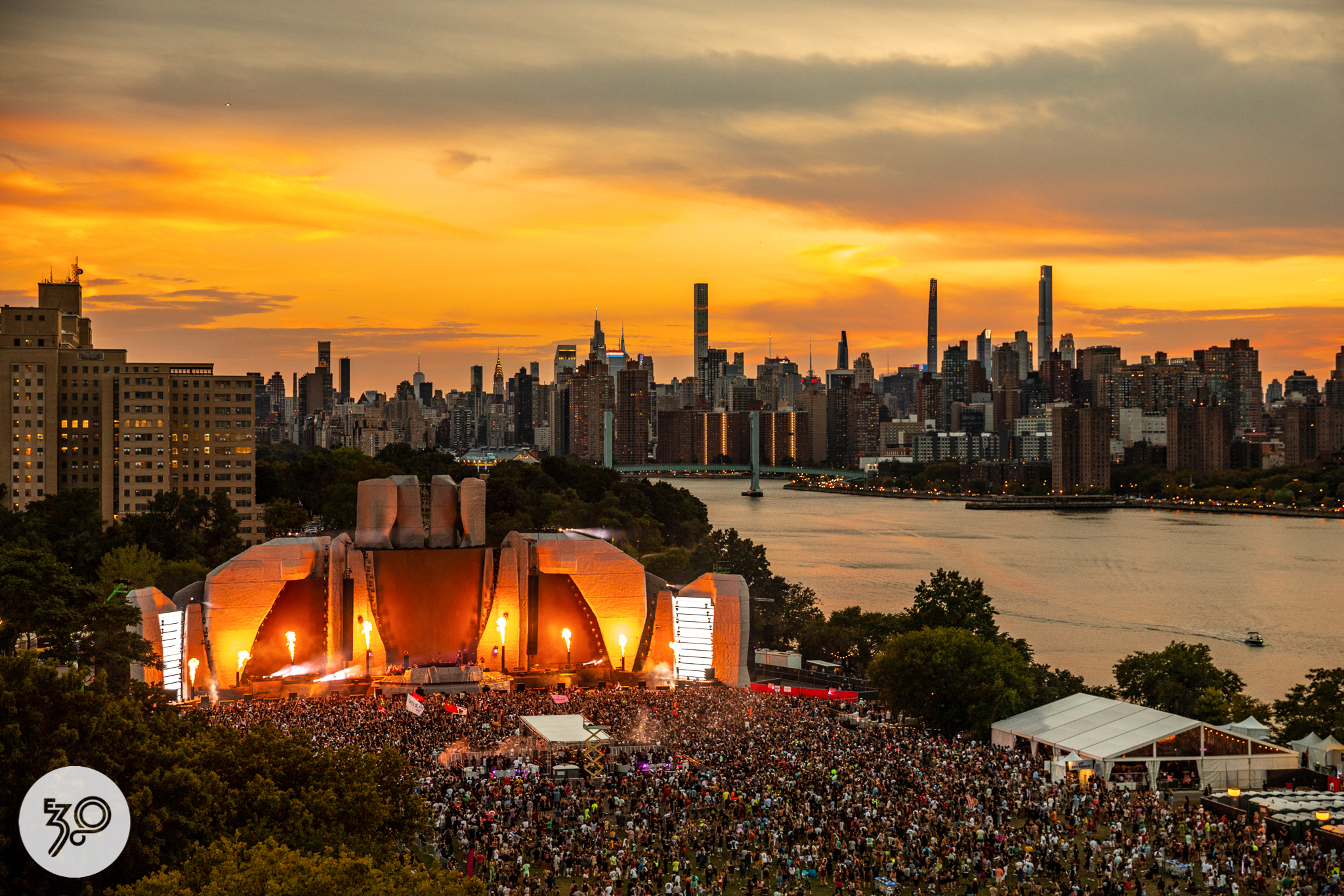 A stage with a packed crowd; the NYC skyline appears in the background.