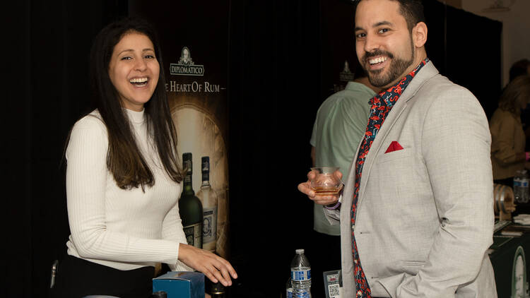 An employee talks with a man having a rum sample.