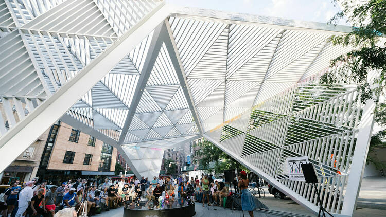 People gather to watch a performer at the NYC AIDS Memorial.