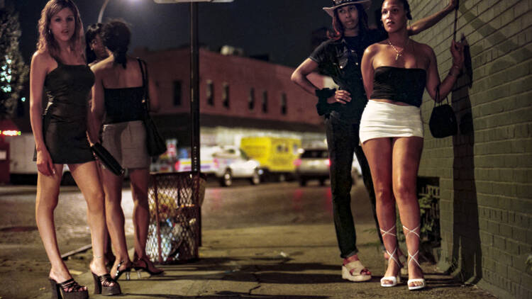 Women standing near a stop sign at night. 