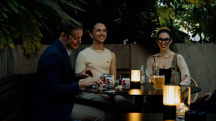 Three people chatting over drinks