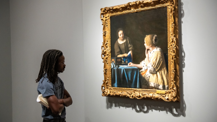 A person looks at a Vermeer painting.