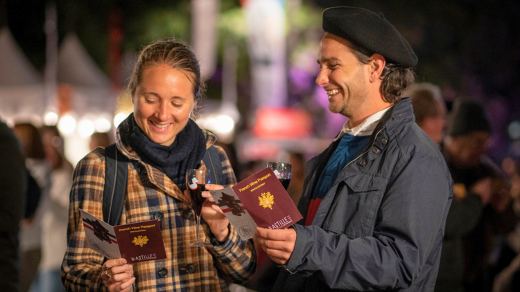 Two people holding passports on the Bastille Wine Walk