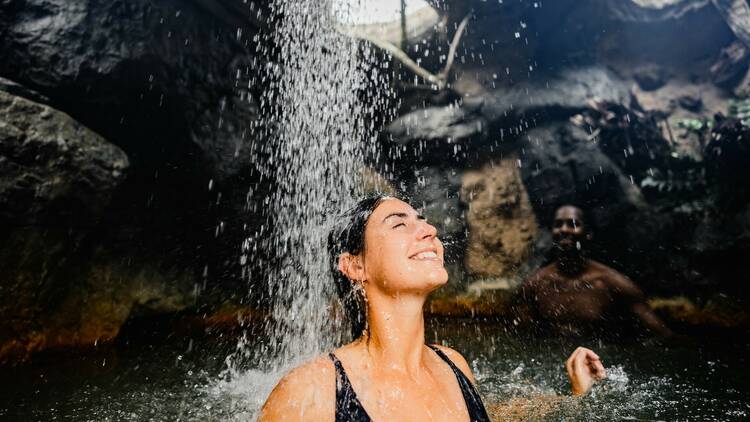 A person basks under a stream of water