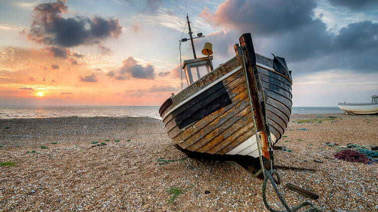 A beautiful sunrise over a wooden fishing boat in Dungeness