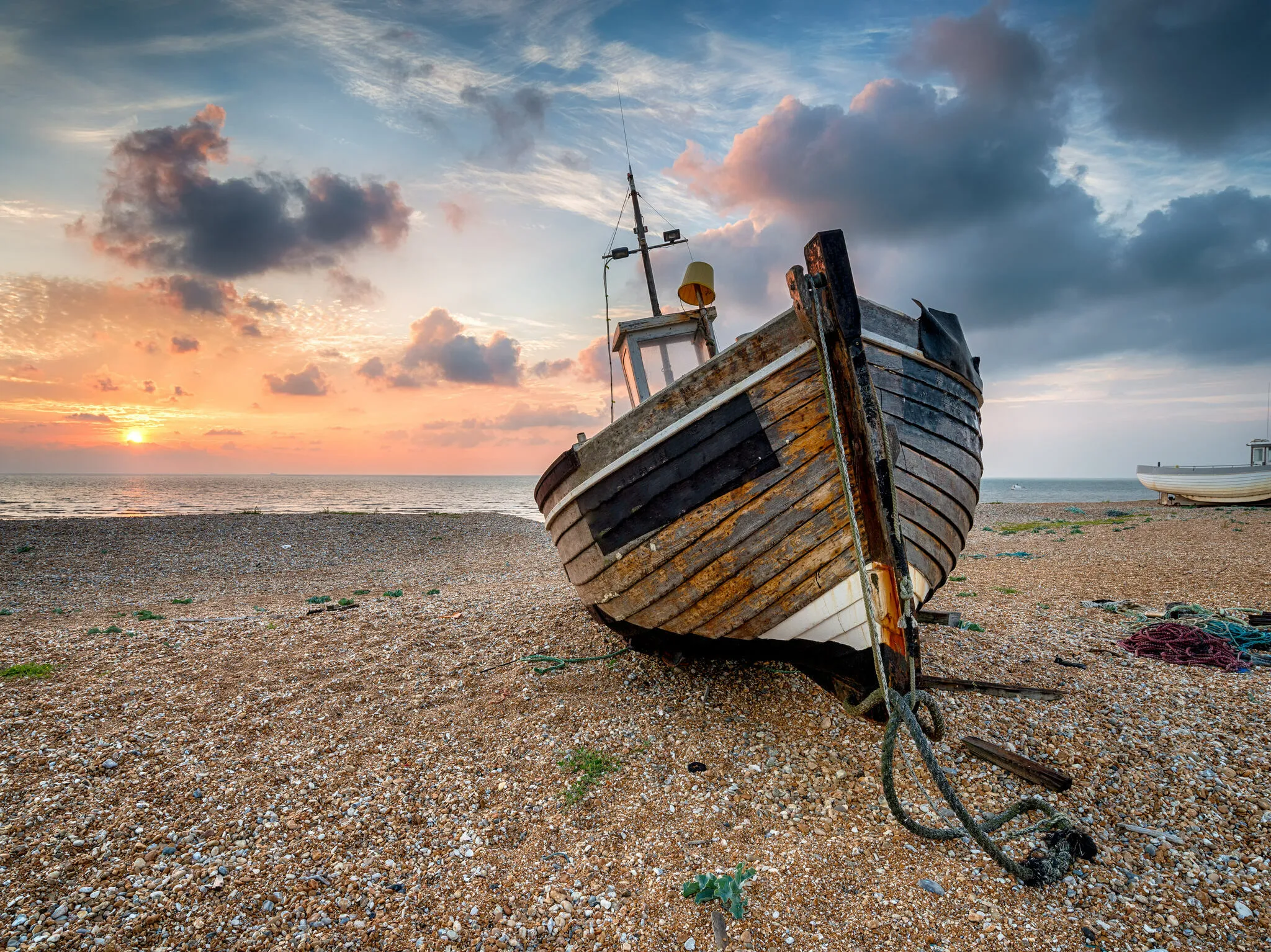 A beautiful sunrise over a wooden fishing boat in Dungeness