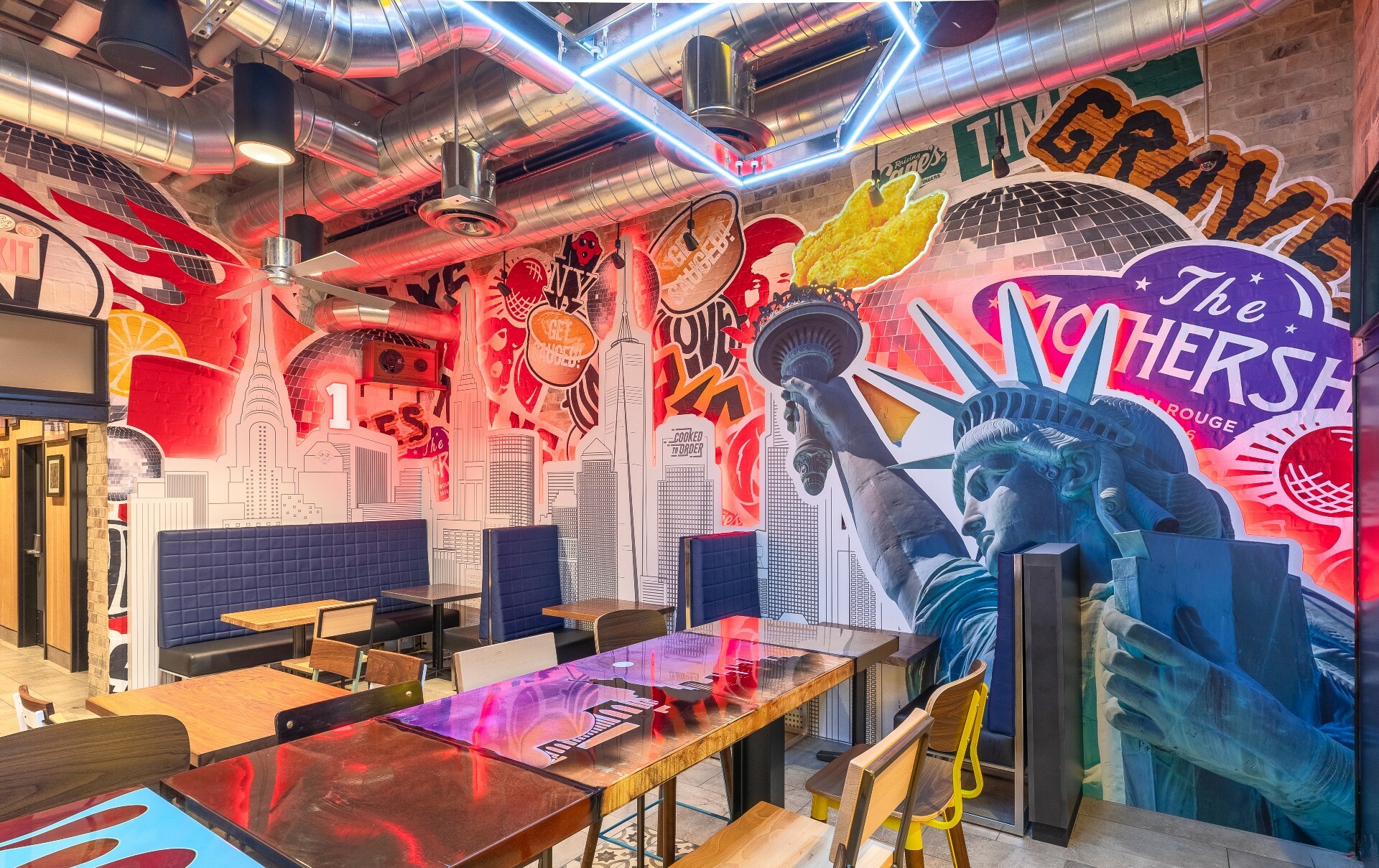 Raising Cane’s interior features pop art wall murals of the statue of liberty and the skyline