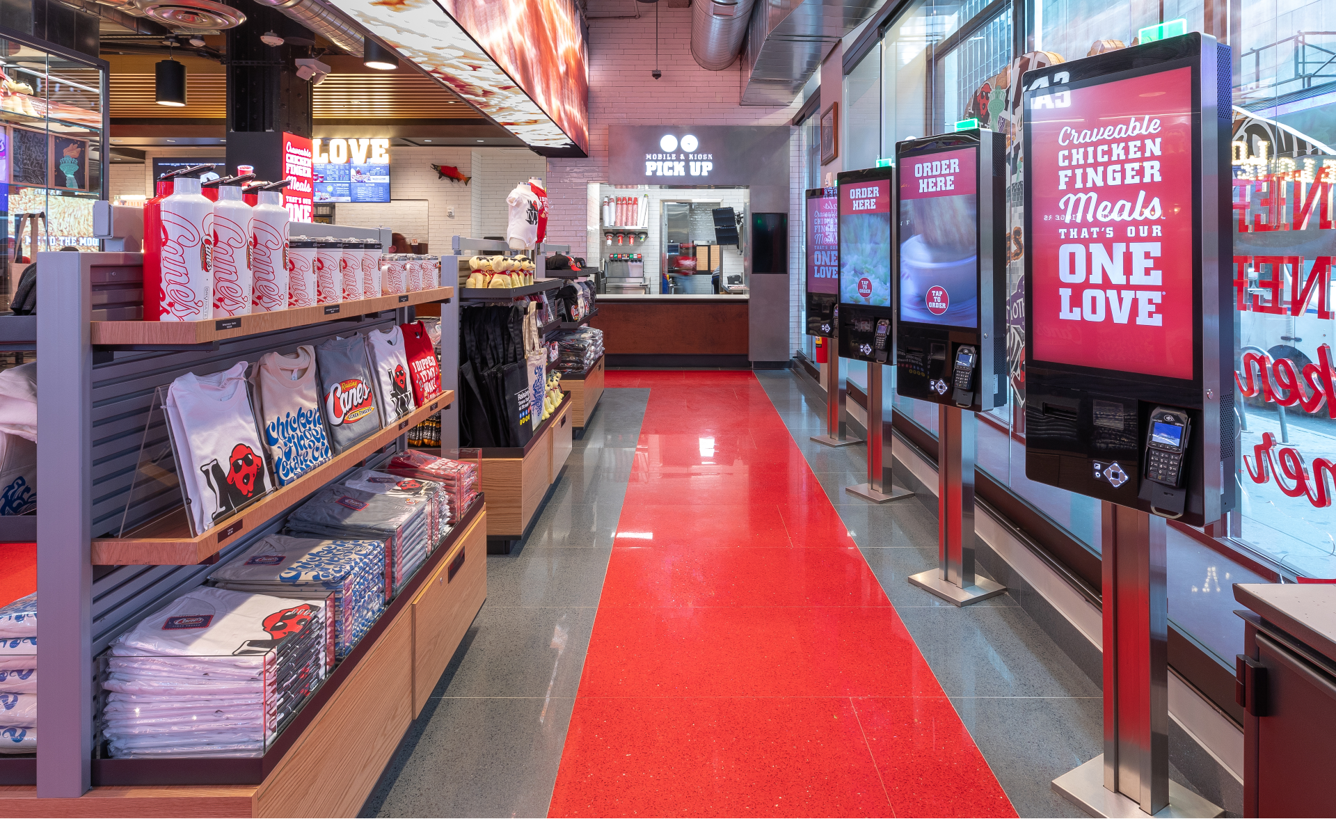 Raising Cane’s interior has ordering kiosks and tons of merch