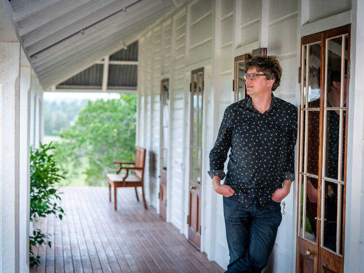 picture of man reclining on a porch up against the wall