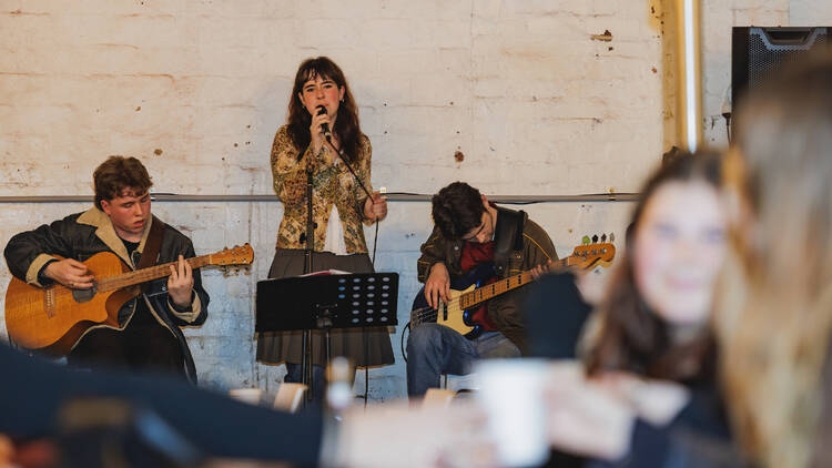 A band performing in a white-walled warehouse.