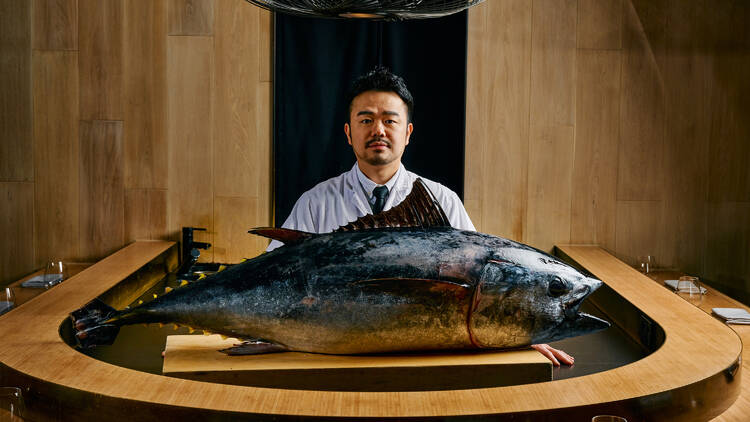 Yonge Kim standing in front of a whole bluefin tuna fish.