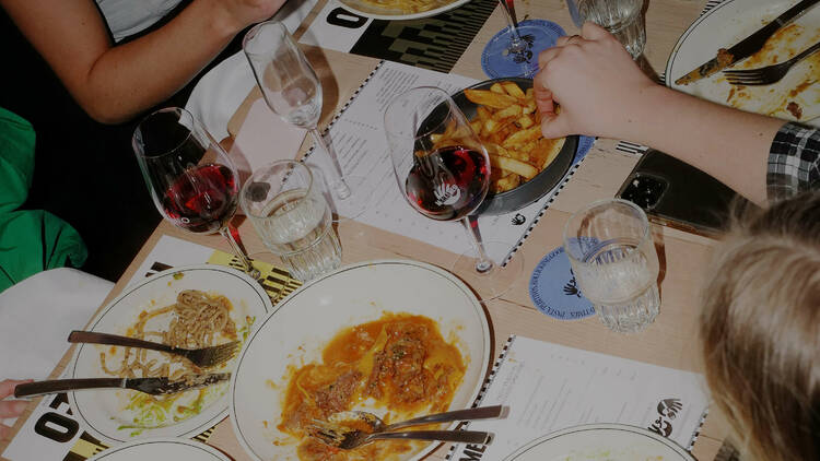 Someone reaching for snacks at a table of assorted Italian dishes.