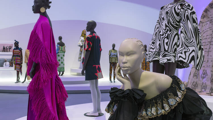 Several mannequins dressed in stylish outfits, including a pink fringed dress.