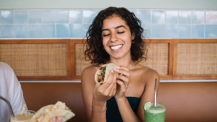 Mujer comiendo tacos