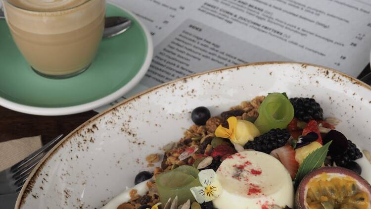 Food and coffee on a table with a menu.