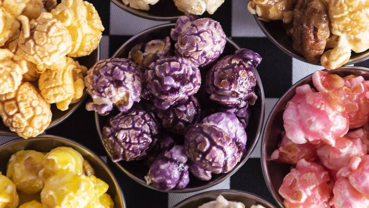 Assorted bowls of brightly coloured popcorn.