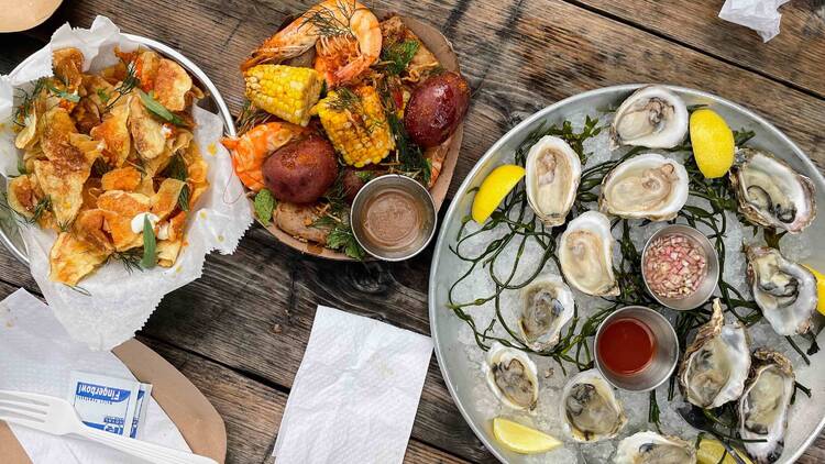 Oysters, shrimp boil and disco chips on a table.