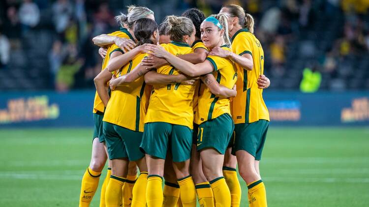 The Matildas in a huddle on the field