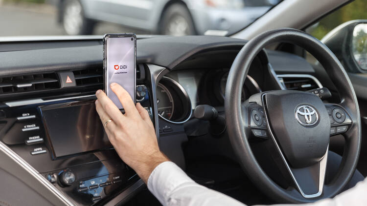 A person using the DiDi app in their car.